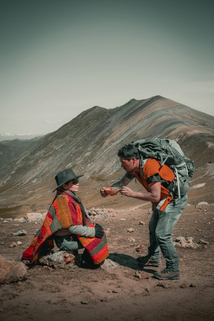 Couple in traditional attire hiking in the Andes, Cusco, Peru.